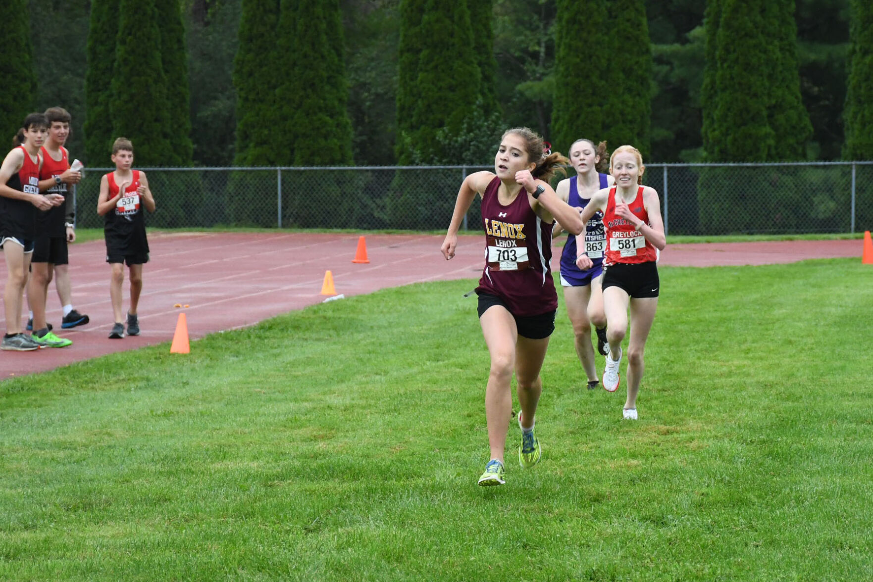 The top three finishers of the girls race approach the finish line